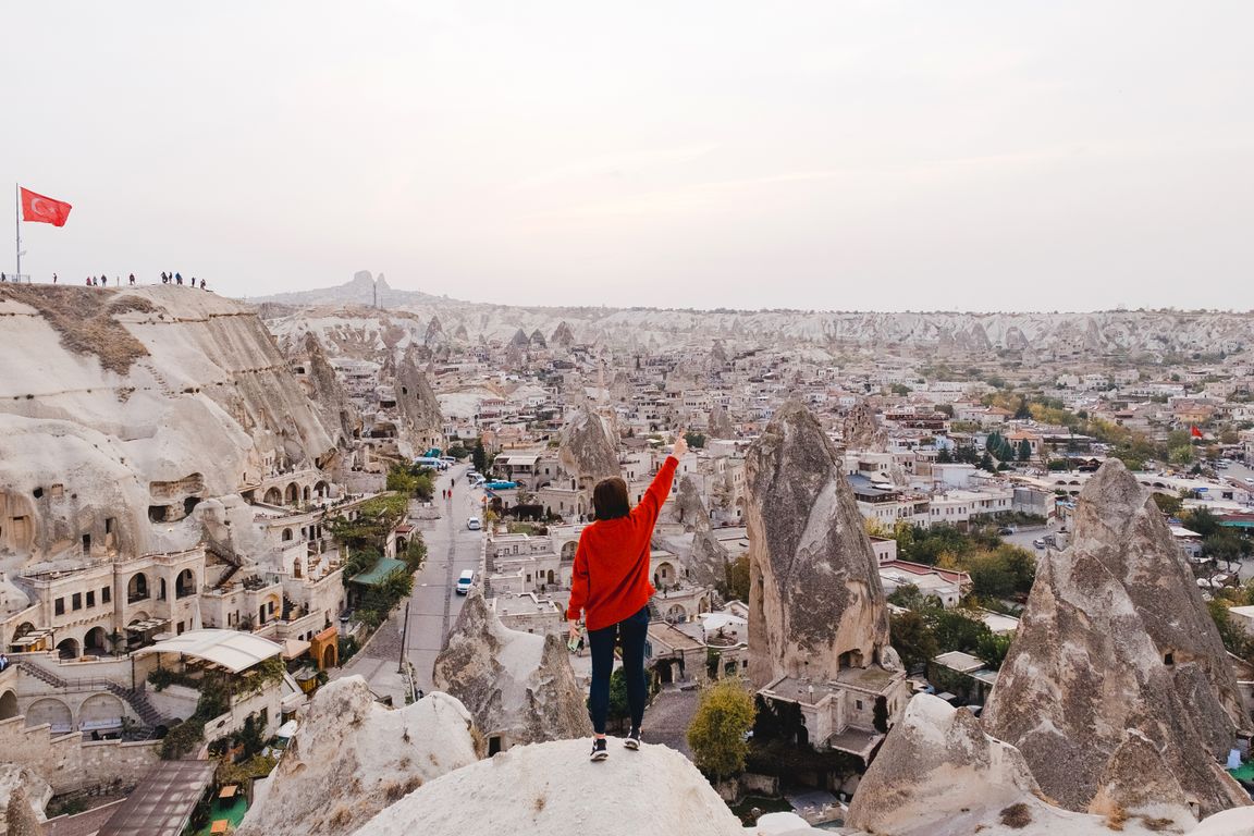 Dozens of hot air balloons floating above Cappadocia valleys at sunrise